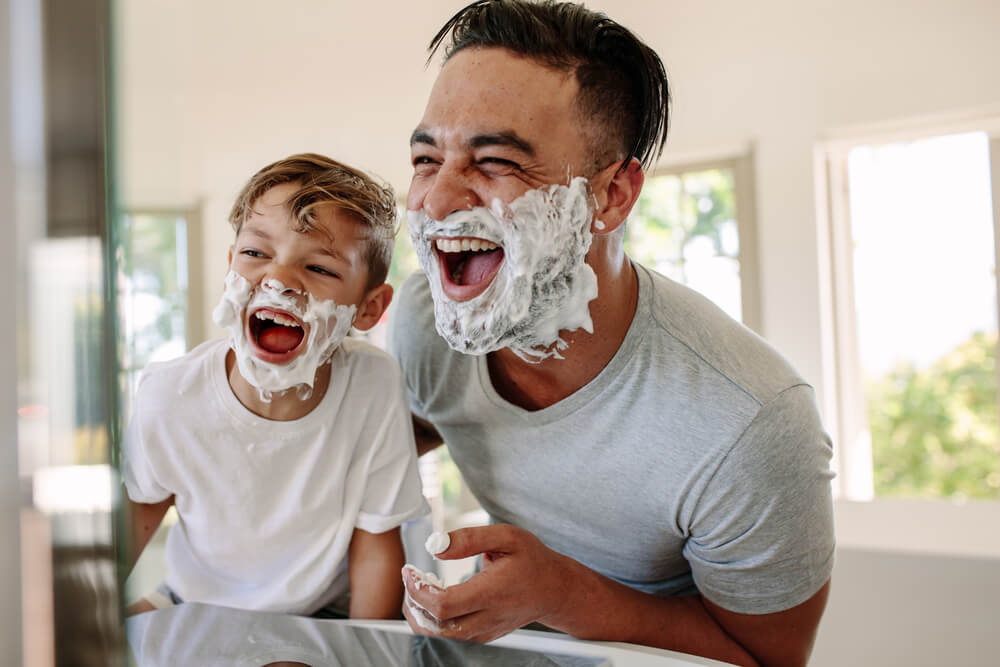 Man and little boy with shaving foam on their faces